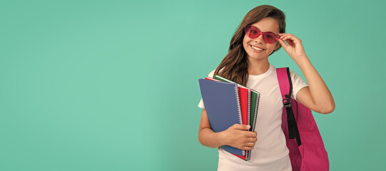 Poster - happy kid with backpack and copybook in sunglasses ready to study at school, school. Banner of schoolgirl student. School child pupil portrait with copy space.