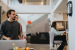 © qunica.com - Casual business meeting in a modern office kitchen with colleagues.