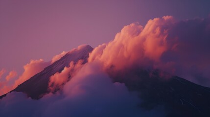 Wall Mural - a mountain covered in clouds with a pink sky in the background and a pink and blue sky in the foregr