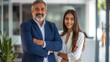 © Studio Nova - Two confident professionals, a man in a navy blazer and a woman in a white shirt, stand with arms crossed in a modern office environment, exuding leadership and partnership.