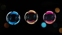  A Group Of Three Glass Balls Sitting Next To Each Other On A Black Surface With A Blurry Background Of Lights In The Middle Of The Spheres Of The Image.
