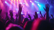 © MP Studio - lively crowd at a concert, with hands raised in the air, silhouetted against a backdrop of vibrant stage lights, capturing the energy and excitement of a live music event.