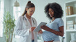 © MP Studio - smiling pregnant woman is looking at a tablet screen shown to her by a healthcare professional in a medical office setting.