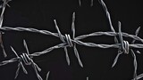 Closeup of metal barbed wire on black background