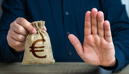 Wall Mural - Stop gesture and euro money bag. Financial difficulties. Economic sanctions, confiscation of funds. The man does not approve of the transaction or loan. Asset freeze seizure.