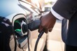 Closeup of man holding power supply cable at EV charging station.