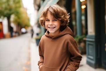 Wall Mural - Portrait of a smiling boy in hoodie standing on the street