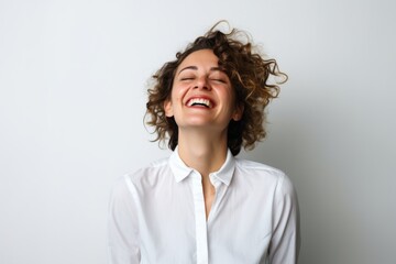 Wall Mural - Portrait of a beautiful young woman with curly hair laughing on white background