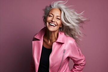 Portrait of a beautiful happy mature woman in a pink jacket.