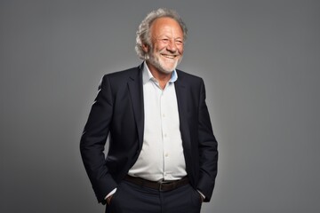 Portrait of a happy senior man smiling at camera over grey background