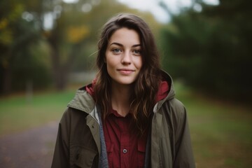 Portrait of a beautiful young brunette woman in the autumn park