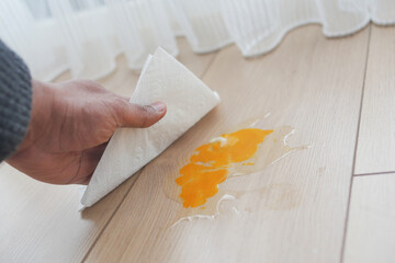 Wall Mural - A man's hand washing the floor with a tissue cleaning egg spill 