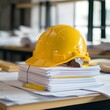 © Avi - Yellow worker helmet in warehouse, construction helmet and blueprint on the table, construction helmet and tools on wood table, calculator and house plan