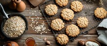 Fresh Oat Cookies On A Rustic Wooden Table With Baking Grid, Ingredients, And Kitchen Utensils Nearby.