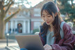 © EduLife Photos - Student Studying on Campus Lawn. Asian university student concentrating on his laptop while sitting on the grass at a college campus.