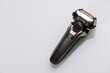 Lifestyle Ideas. Closeup of Black Modern Stylish Five Blades Electric Mens Washable Shaver on White Reflective Surface.
