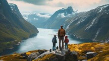 A Family Stands With Their Back And Admires The View Of Snowy Mountains And Lake. A Traveler Traveling On Vacation In The Most Beautiful Place In The World. Winter Vacation
