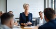 © Stock Pix - a boardroom setting, of a mature businesswoman confidently presenting her ideas to a group of attentive colleagues