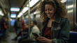 © redflower - A woman on the subway smiles and plays with her smartphone