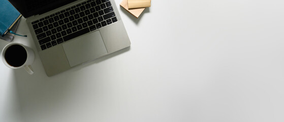 Wall Mural - Laptop, cup of coffee and notebooks on white working desk. Flat lay, top view with copy space