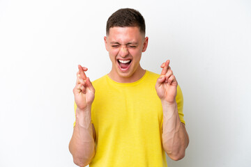 Wall Mural - Young brazilian man isolated on white background with fingers crossing