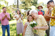 © Halfpoint - Beautiful senior birthday woman receiving flowers from granddaughter.