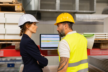 Wall Mural - Female manager scolding employee in modern industry factory. Worker making mistake. Production manger is angry, dissatisfied for worker's poor quality work, safety viaolations.