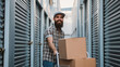 © Bogdan - Handsome bearded man loading cart with cardboard boxes into self storage unit