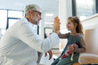 © Halfpoint - Friendly pediatrician giving high five to little patient. Cute preschool girl in greeting doctor in hospital corridor.