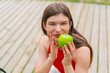 © luismolinero - Young pretty woman at outdoors holding an apple