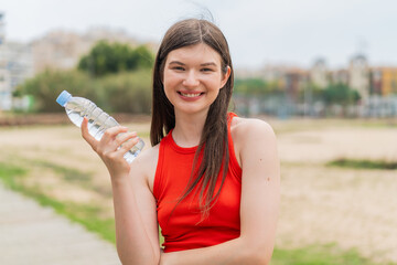 Wall Mural - Young pretty Ukrainian woman with a bottle of water at outdoors