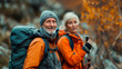 © VicPhoto - Pareja de  50 años andando por la montaña con ropa de montañero, mochila y gorro