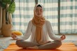 healthy muslim woman wearing hijab doing yoga pilates meditating in a room on orange mattress with eyes closed lotus pose in a room