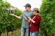 © scharfsinn86 - Couple of farmers control drone with a tablet. Smart farming and agriculture 4.0.