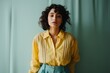 © Iigo - stylish young woman in yellow blouse and blue skirt looking at camera