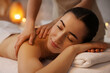 © New Africa - Woman receiving back massage on couch in spa salon