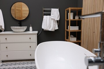 Poster - Stylish bathroom interior with heated towel rail and white tub