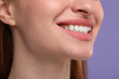 © New Africa - Woman with clean teeth smiling on violet background, closeup