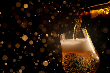 Wall Mural - Light beer foams and pouring from bottle in glass on dark background.