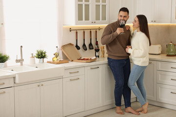 Wall Mural - Happy young couple spending time together in kitchen. Space for text