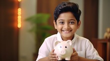 Indian, Asian Kid 6 Years Boy Saving Money By Putting It In Pig Shape Piggy Bank, Smiling, Hugging And Thinking