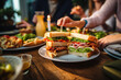 © pilipphoto - People enjoying a delicious meal, club sandwiches with ham and cheese while dining out