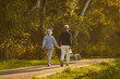 © Studio Romantic - Backside view of a senior family couple enjoying a stroll hand in hand through the city park. Their active vacation showcases the beauty of shared moments and the fulfillment found in simple walk.