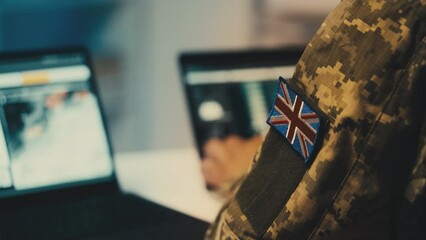 UK military commander studying intelligence data on computer, planning operation