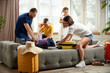 © master1305 - Man, woman, boy and girl sorting garments for travel, nd packaging bags in bright living room. Joyful mood before trip. Family resort. Concept of tourism, holiday, vacation, relaxation. Ad