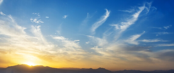 Wall Mural - Panoramic view sky sunset cirrus clouds mountains.