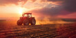 Tractor in the field under sunset light, tillage in spring, preparation for sowing