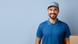 Professional smiling cheerful fun delivery guy employee man wear blue cap t-shirt uniform workwear work as dealer courier hold cardboard box isolated on plain light beige background. Service concept