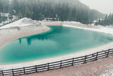 Fototapeta  - Heart shaped turquoise water alpine lake in Dolomites mountains, Cortina dAmpezzo, Italy in snowy spring day. Winter in spring with snow in Italian Alps