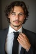 © Sean Maxhell - elegante uomo d'affari che si sistema la cravatta